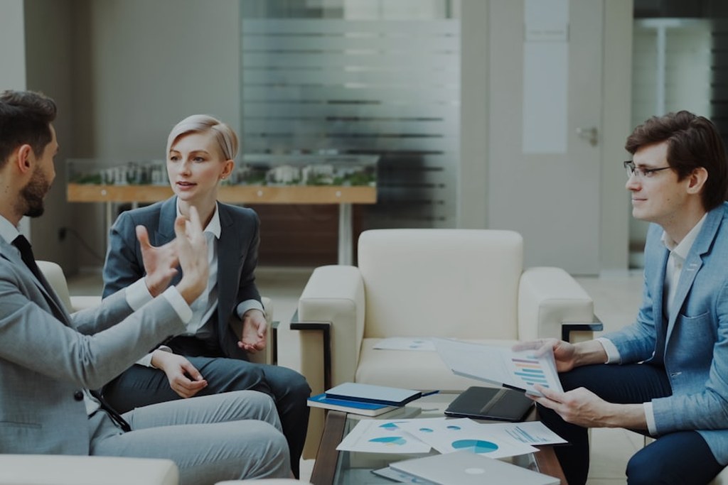 Three business professionals collaborating in a meeting demonstrating emotional intelligence and leadership skills