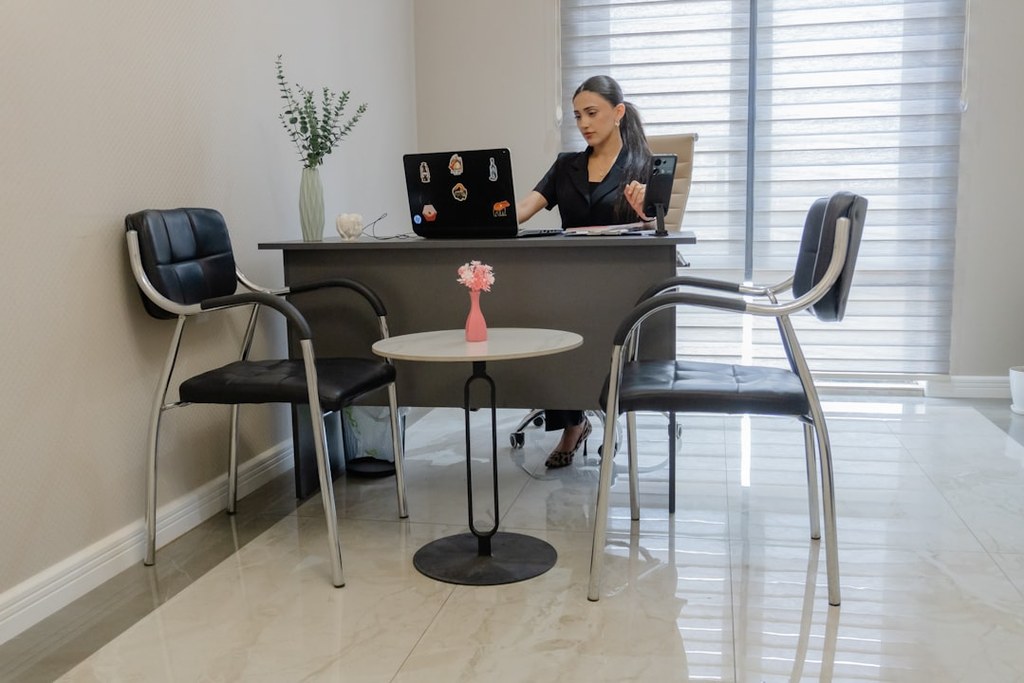 Professional woman working at laptop desk representing hybrid coaching and counseling for leaders