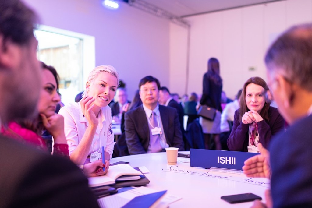 Diverse professionals collaborating around a conference table during a leadership development workshop