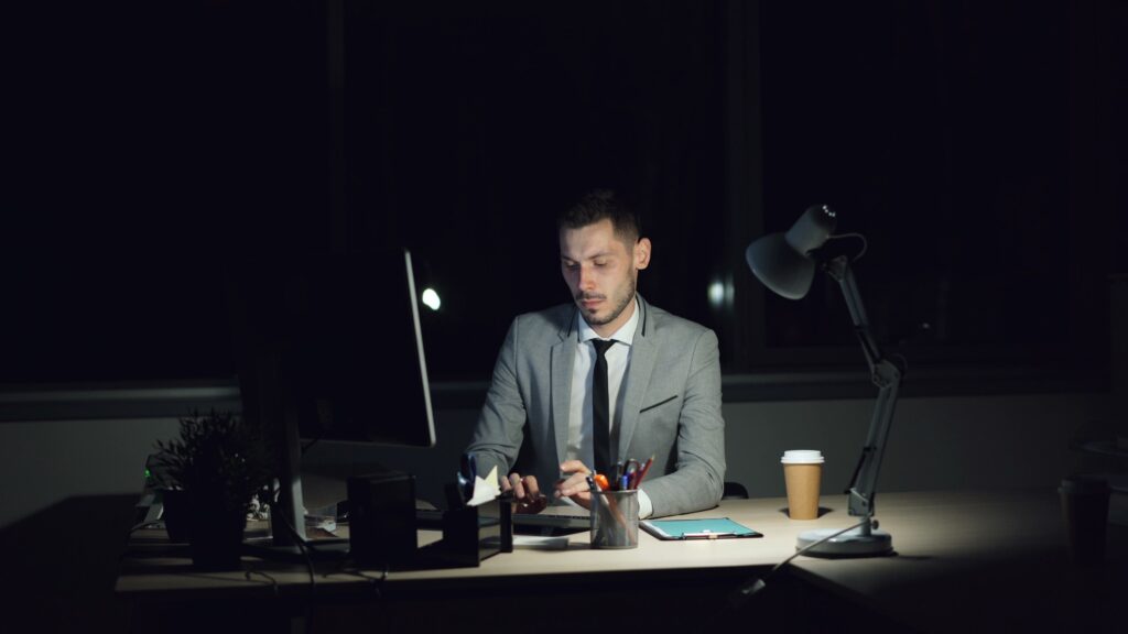 Leader working alone late at night at a glowing computer